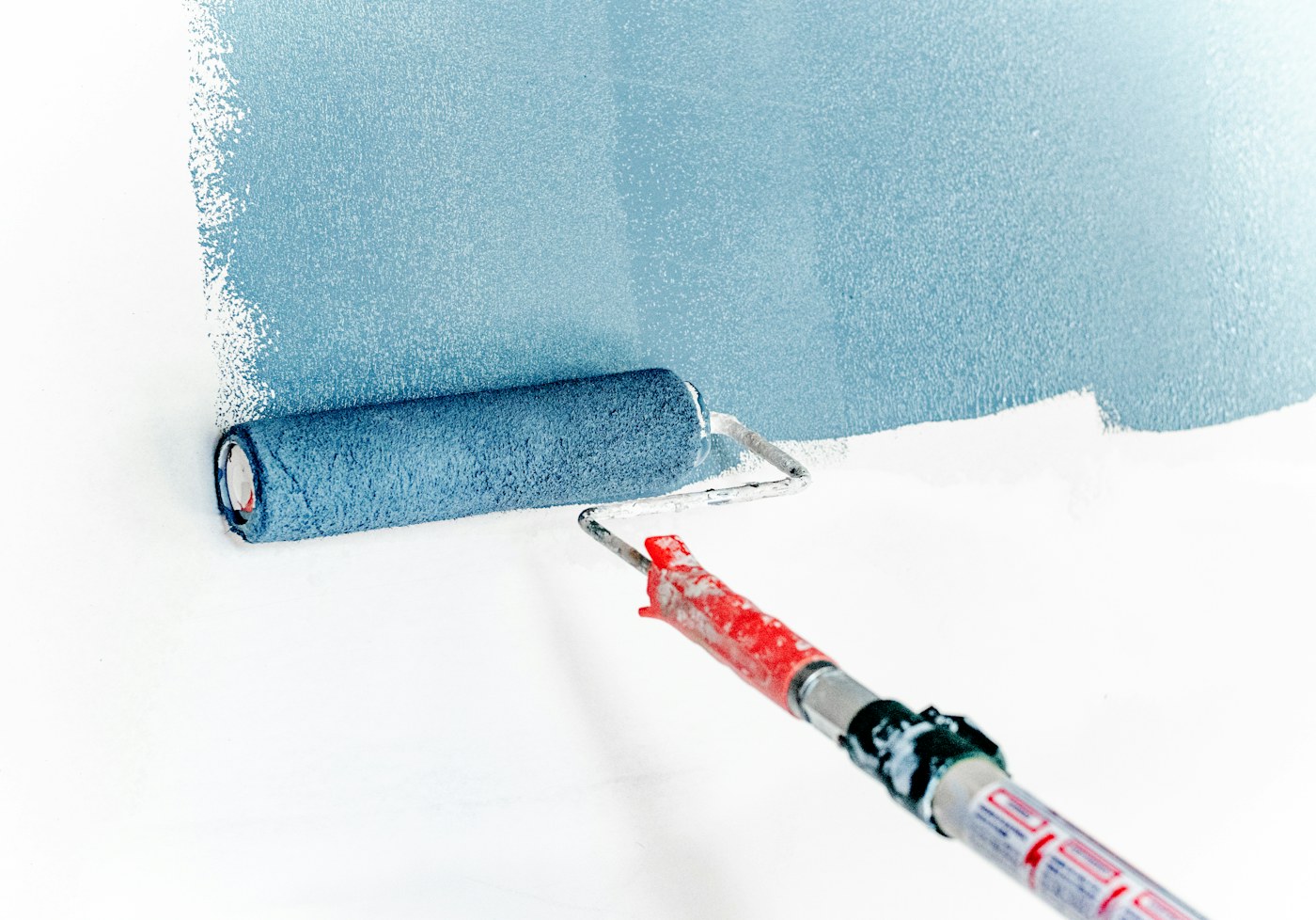 Paint roller applying a fresh coat of paint